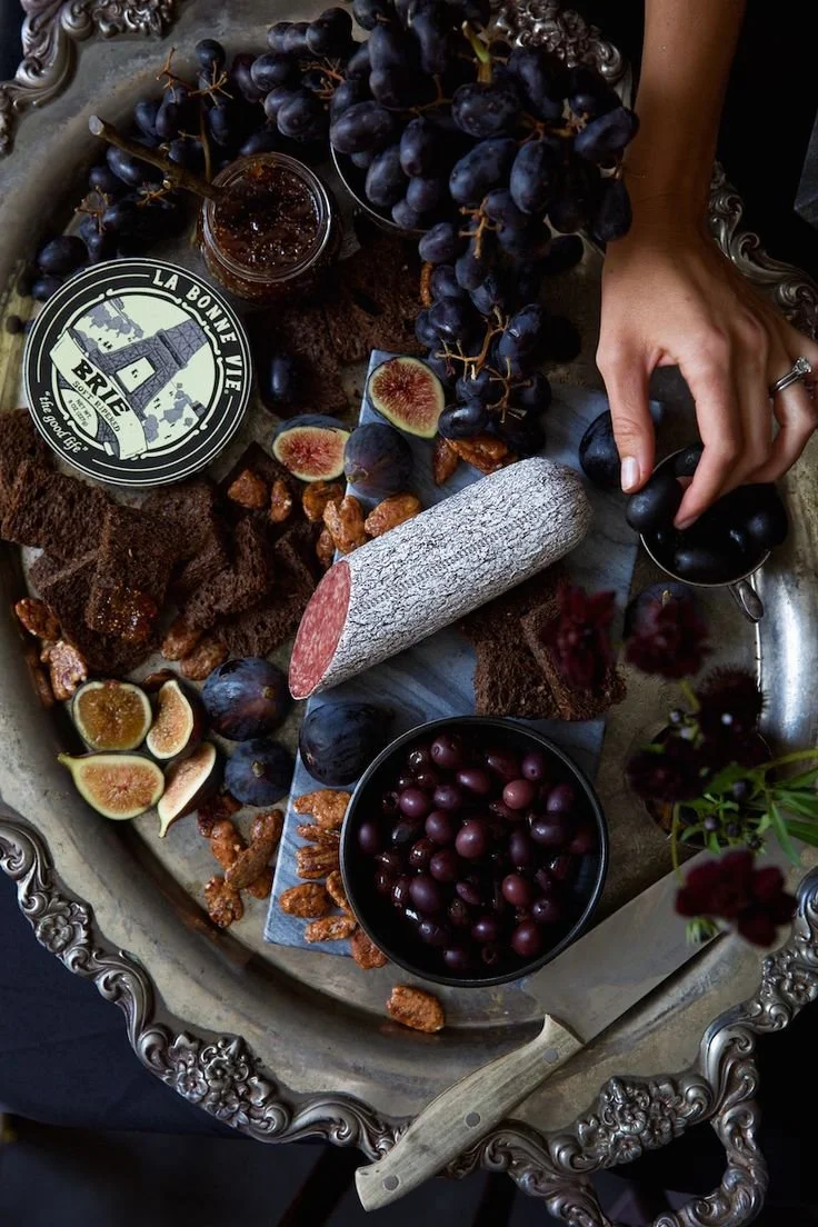Elegant Halloween dinner party table setup with spooky decorations and festive dishes.