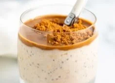 Bowl of cookie butter protein overnight oats topped with nuts and fruit