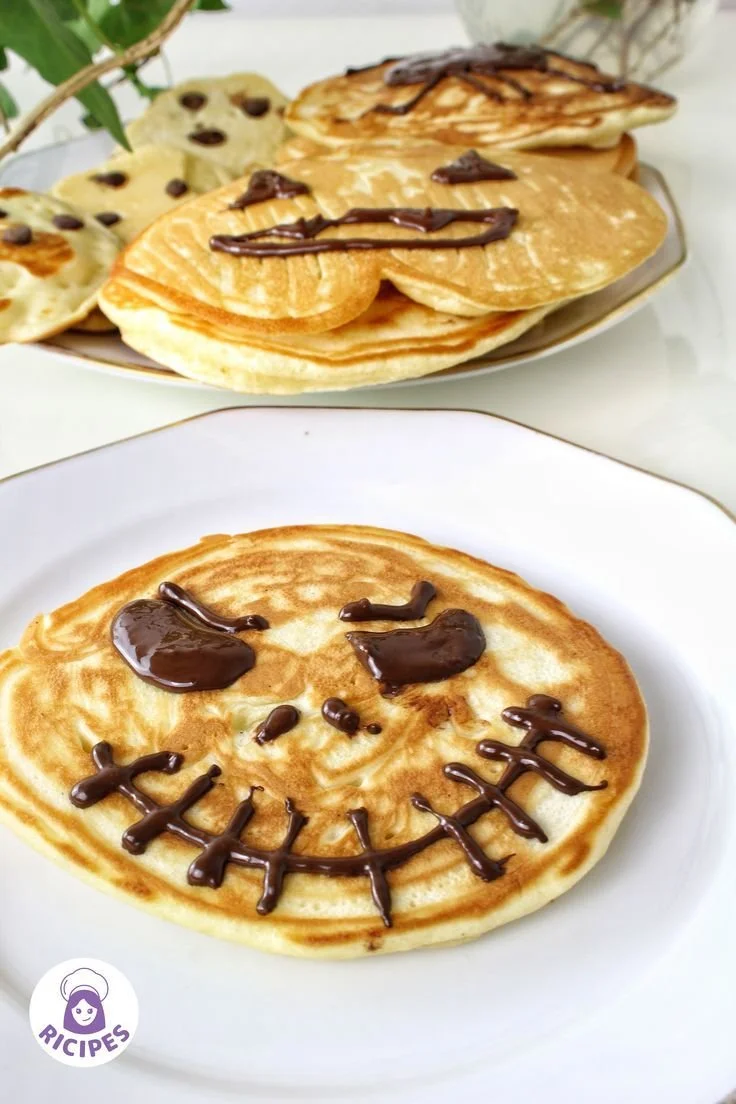 Plate of festive Halloween pancakes decorated with spooky toppings