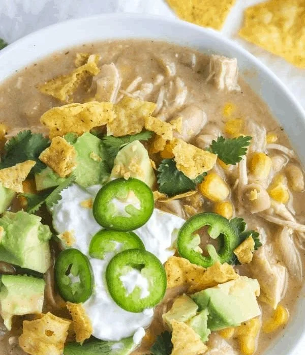 Bowl of healthy white chicken chili topped with cilantro and lime slices