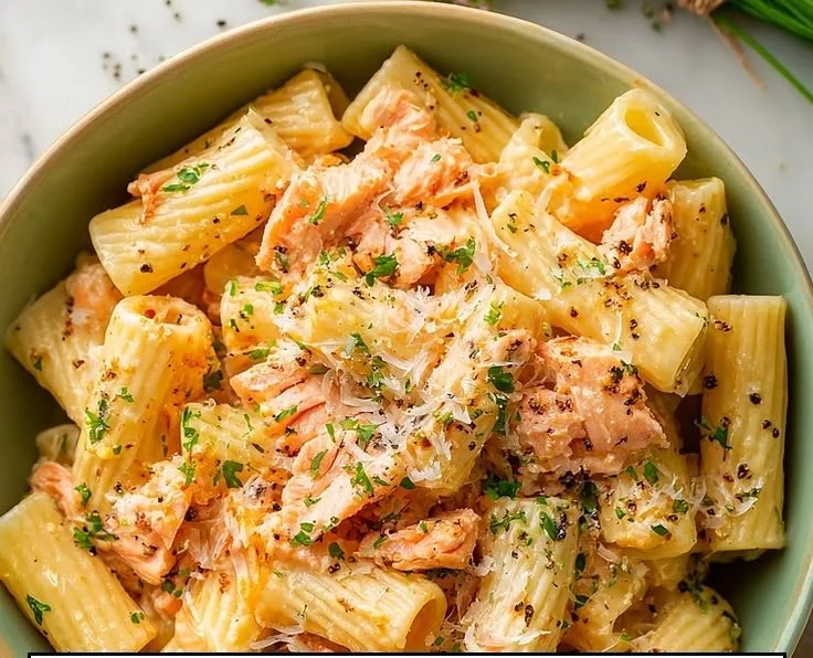 Plate of irresistible salmon pasta without cream, garnished with herbs.