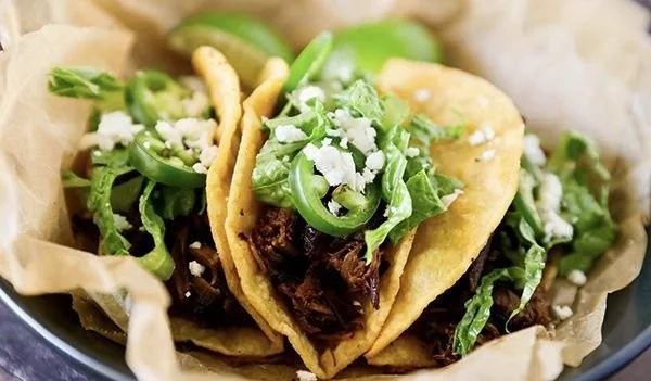 Delicious slow cooker barbacoa served in tacos with fresh toppings