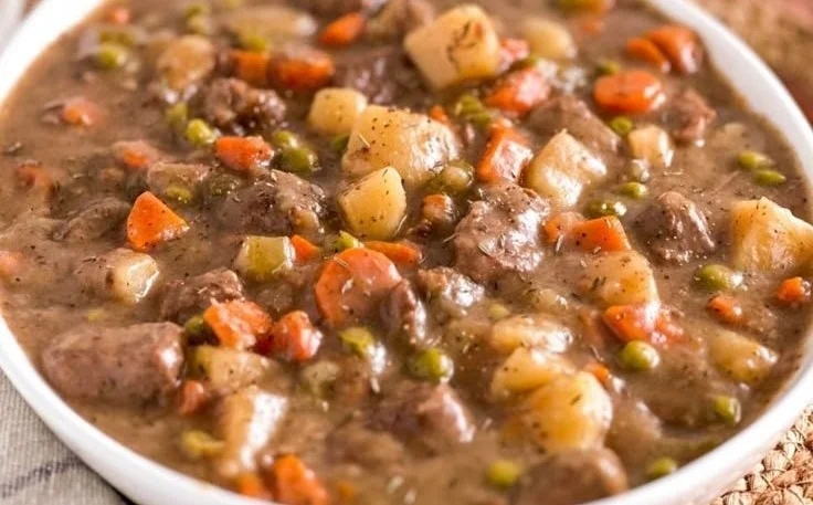 Bowls of slow cooker gluten-free beef stew garnished with herbs