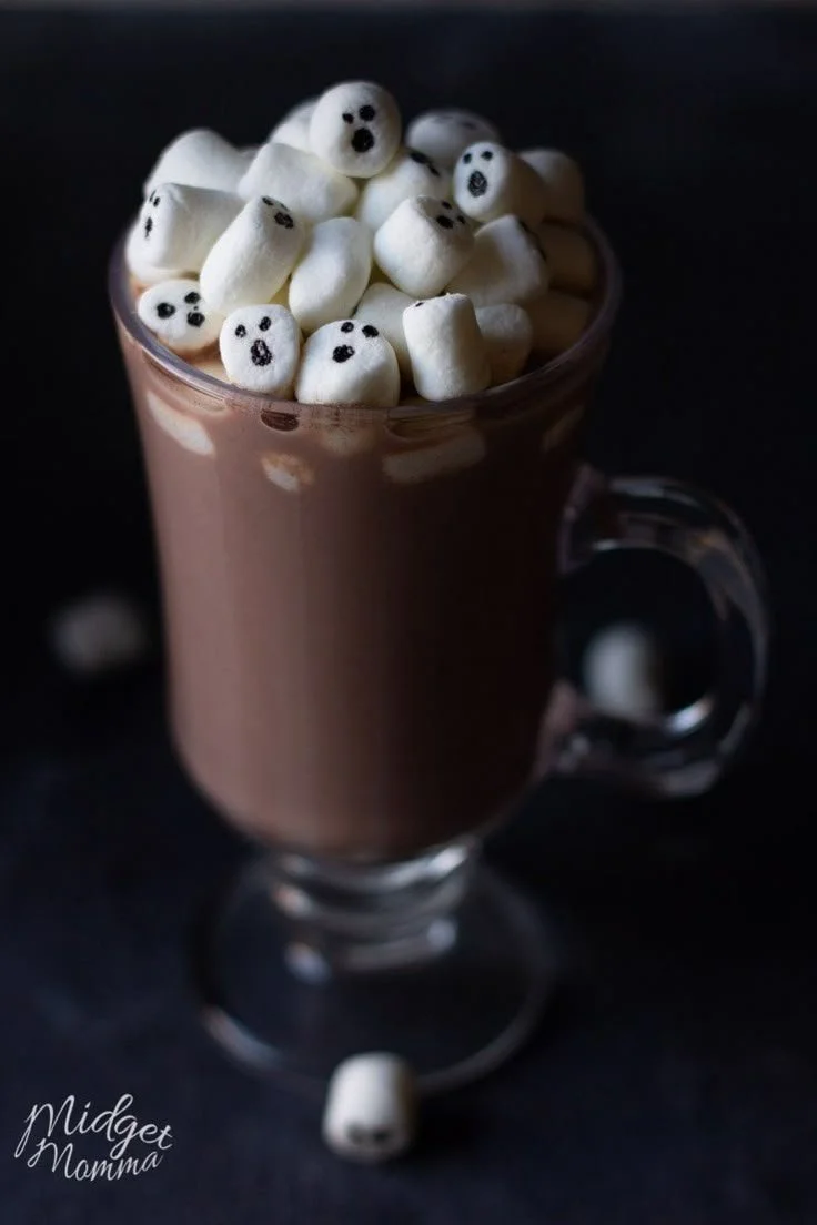 Bowl of super cute Halloween hot chocolate topped with marshmallows and sprinkles.